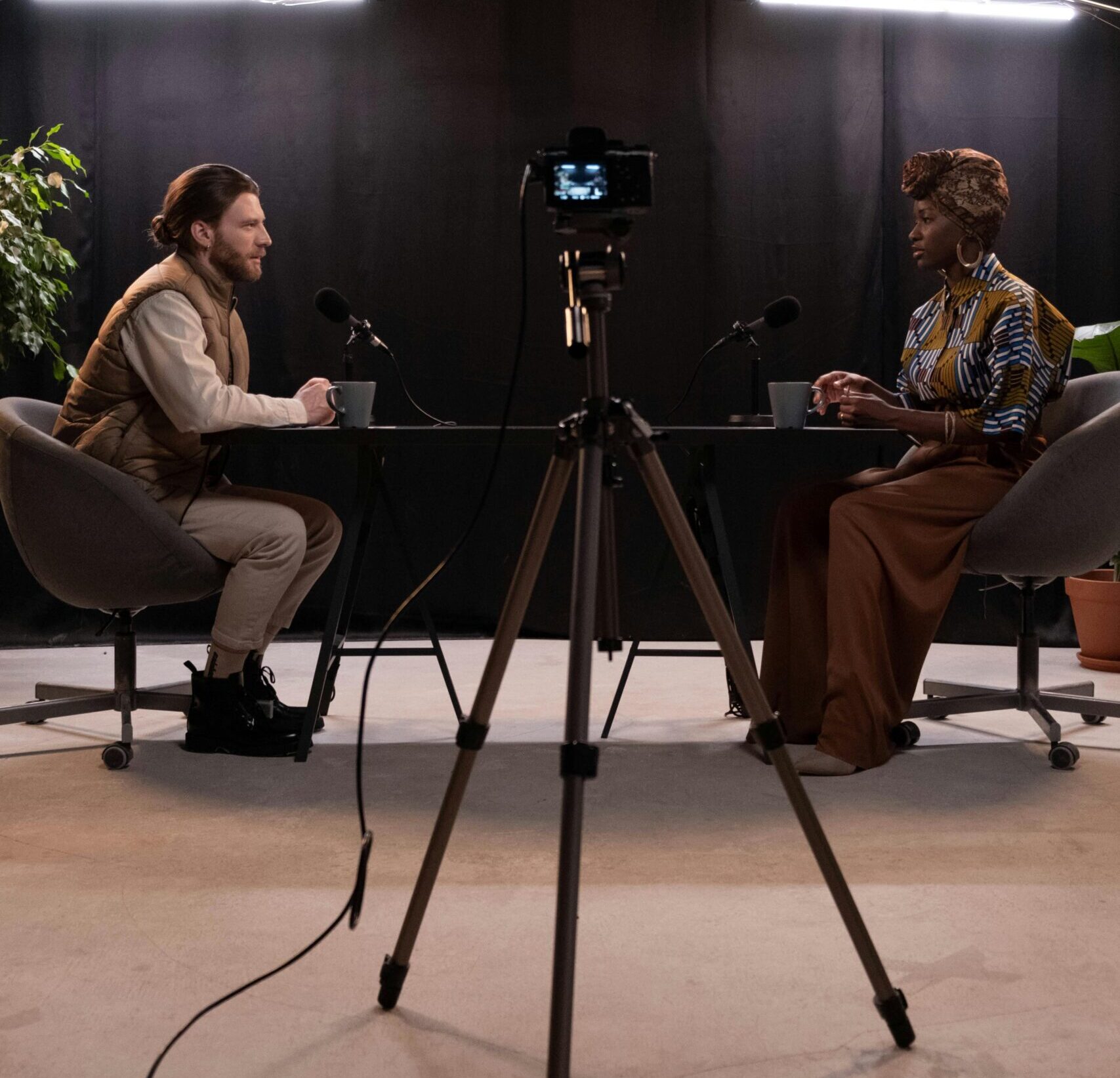 Dynamic podcast session featuring two hosts with studio lighting and recording equipment.